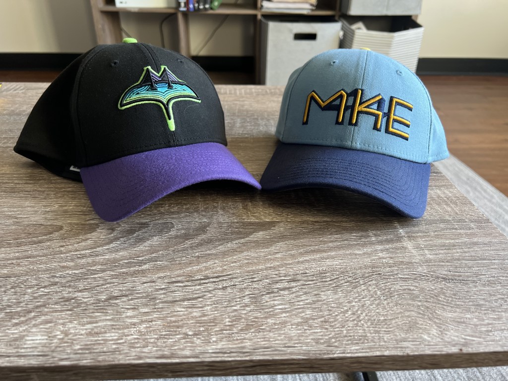 my Tampa Bay Rays City connect hat and Milwaukee Brewers 2022-25 City Connect hat sits next to each other